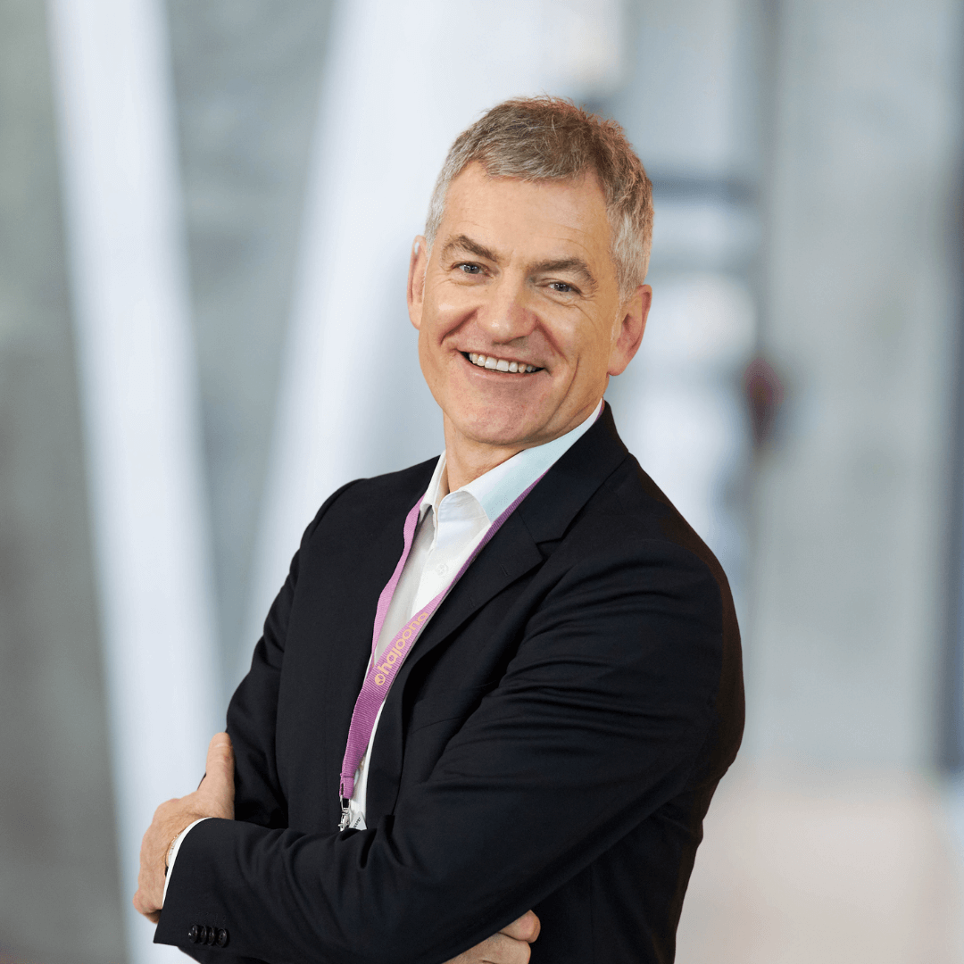 Thomas Klaholz, Produktexperte bei hajoona, steht mit verschränkten Armen in einem modernen Gebäude und lächelt freundlich in die Kamera.